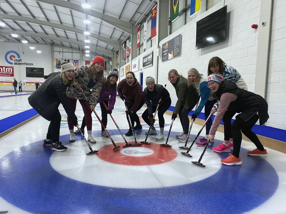 A group on the ice with brooms